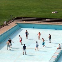 Kids playing soccer in an empty swimming pool